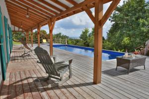 une terrasse avec une chaise et une table et une piscine dans l'établissement Villas Coccoloba & Jacaranda, à Capesterre