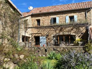 an external view of a stone house with a balcony at Les IRIS des Rieux in Sallelles