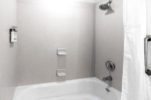een badkamer met een wit bad en een douche bij Holiday Inn Express Hotel & Suites Salina, an IHG Hotel in Salina