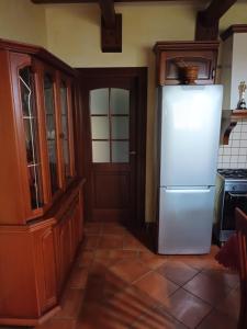 una cucina con frigorifero bianco e armadietti in legno di Casa di campagna Villa De Luca a Bellante