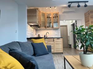 a living room with a blue couch and a kitchen at FeelHome Apartment with kitchen in Krakow