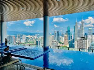 uma piscina com vista para a cidade em The Luxe Suites KLCC by Cozy Stay em Kuala Lumpur