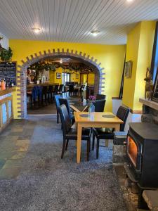 a restaurant with a table and chairs and a fireplace at Kingarth Hotel in Kilchattan