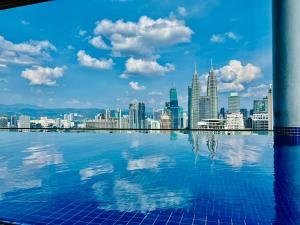 uma vista para o horizonte da cidade a partir de uma piscina em The Luxe Suites KLCC by Cozy Stay em Kuala Lumpur