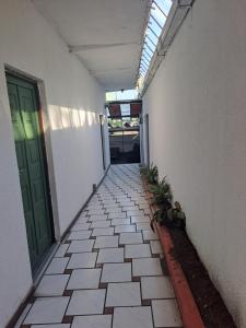 an empty walkway with a green door and plants at Hotel Luigi in San Salvador
