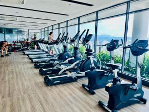 a gym with a row of treadmills and machines at The Luxe Suites KLCC by Cozy Stay in Kuala Lumpur