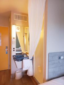 een badkamer met een wastafel en een spiegel bij ibis budget Saint-Brieuc Yffiniac in Yffiniac