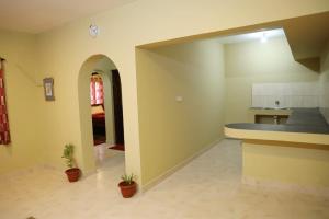a room with a kitchen with a counter and plants at LA SIESTA in Ooty