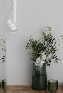 a vase filled with white flowers sitting on a table at E l e v e n in Ivano-Frankivsʼk