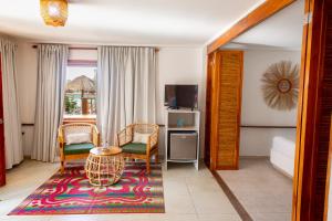 uma sala de estar com uma mesa e cadeiras e uma televisão em Hotel Isla del Sol em Isla Grande