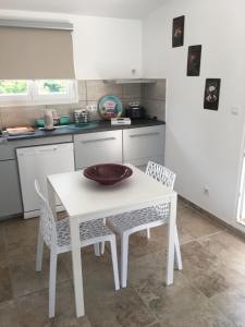 a kitchen with a white table and two chairs at maisonette Cosi in Fayence
