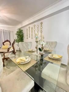a living room with a glass table and chairs at Super Cozy n´Confortable apart. in Ensanche Los Minas