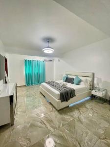 a bedroom with a bed and a blue curtain at Super Cozy n´Confortable apart. in Ensanche Los Minas