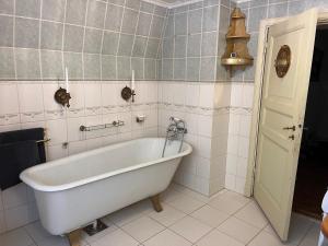 瓦爾科瑞爾的住宿－Charming Countryside Cottage，浴室设有白色浴缸,铺着瓷砖。