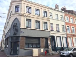 un edificio en una calle con un hombre parado frente a él en Citadelle Vauban, T2 l'encyclopédie en Lille