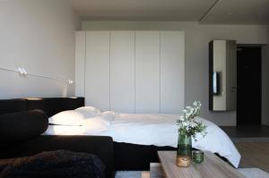 1 dormitorio con 1 cama y 1 mesa con flores en E l e v e n, en Ivano-Frankivsk