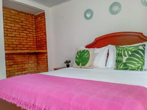 1 dormitorio con 1 cama grande con manta rosa en San José HOUSE, en Leticia