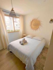 - une chambre avec un grand lit blanc et une fenêtre dans l'établissement Studio 7 EDEN, à Saint-Tropez