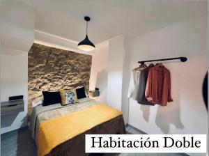 a bedroom with a bed and aptiondb sign on the wall at Cueva Luxe Las Calcetas in Setenil