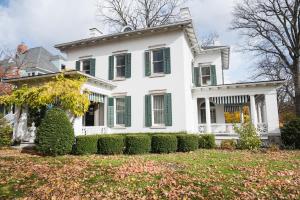 a white house with green shutters and a yard at Canandaigua Guesthouse in Canandaigua