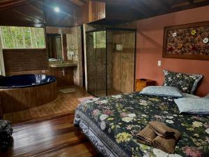 a bedroom with a bed and a bath tub at Casa Araucária in Visconde De Maua