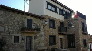 un edificio de piedra con ventanas y balcones. en Vía Caparra Superior, en Oliva de Plasencia