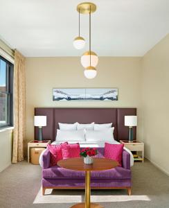 a living room with a purple couch and a bed at 21c Museum Hotel Kansas City in Kansas City