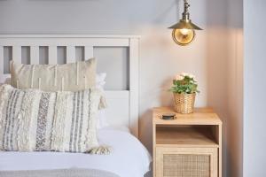 a bedroom with a white bed with a wooden night stand at Host & Stay - Poplar Villas in Ramsgate