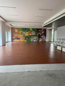 a large room with a hard wood floor and a painting at Easytrip in Lucknow +23 photos