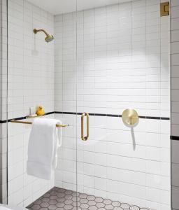 La salle de bains est pourvue d'une douche avec une porte en verre. dans l'établissement 21c Museum Hotel Kansas City, à Kansas City