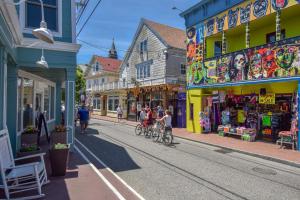 un grupo de personas montando bicicletas por una calle en Oasis on Commercial Street w Balcony, en Provincetown