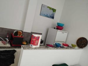 a kitchen counter with some dishes and a refrigerator at Appartement à Carthage byrsa in Carthage