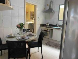 a kitchen with a table with chairs and a refrigerator at Apartamento Encantador C in Montes Claros