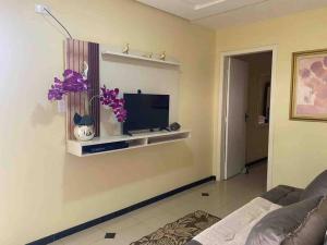 a living room with a tv on a wall at Apartamento Encantador C in Montes Claros