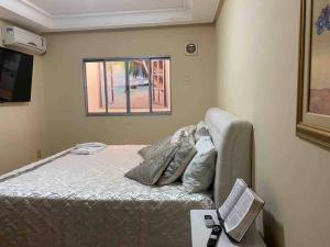 een kleine slaapkamer met een bed en een raam bij Apartamento Encantador C in Montes Claros