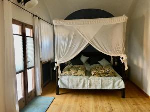 1 dormitorio con 1 cama con dosel en Loft Wohnung im Stall eines ehemaligen Pfarrguts, en Tacherting
