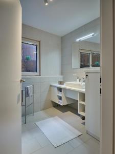 ein weißes Badezimmer mit einem Waschbecken und einem Spiegel in der Unterkunft Haus Fünf mit 2 Apartments und Studio-Loft mit Terrasse in Melk