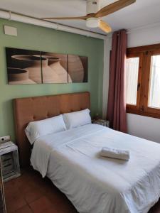 um quarto com uma cama grande e um cobertor branco em L'Olivera Casa Rural em Castellbisbal