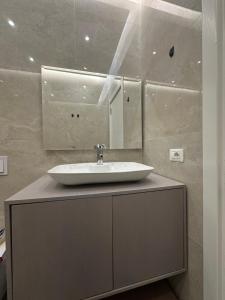 a bathroom with a sink and a mirror at Luxury Apartment - San Pietro in Durrës
