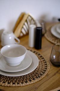 - une table en bois avec un bol blanc et des assiettes dans l'établissement Blue Crystal View, à Kavala