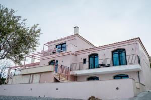 Una gran casa blanca con balcones en la parte superior. en Blue Crystal View, en Kavala