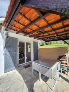 a patio with a table under a roof at Maison de campagne, au calme. in Carlux +1 photo