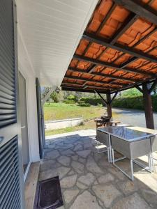 a patio with a table and a wooden roof at Maison de campagne, au calme. in Carlux