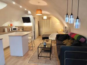 a living room with a couch and a kitchen at Le logis du Barry in Montpeyroux +10 photos