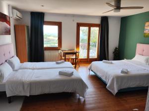 a hotel room with two beds and a table at L'Olivera Casa Rural in Castellbisbal
