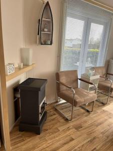 a living room with a chair and a stove at Chalet + tiny house nabij strand in Petten +36 photos