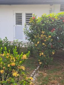 une maison blanche avec une porte blanche et quelques fleurs dans l'établissement KazKaramel, à Rémiré