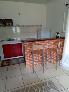 uma cozinha com duas cadeiras e um balcão de tijolos em KazKaramel em Rémiré