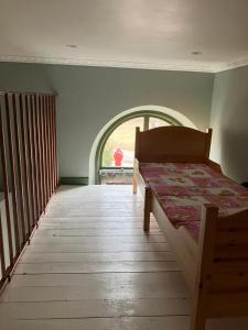 a bedroom with a bed and an arched window at Stationshus apartment in Hallstahammar