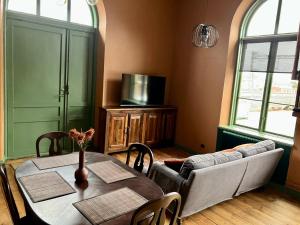 a dining room with a table and a couch at Stationshus apartment in Hallstahammar